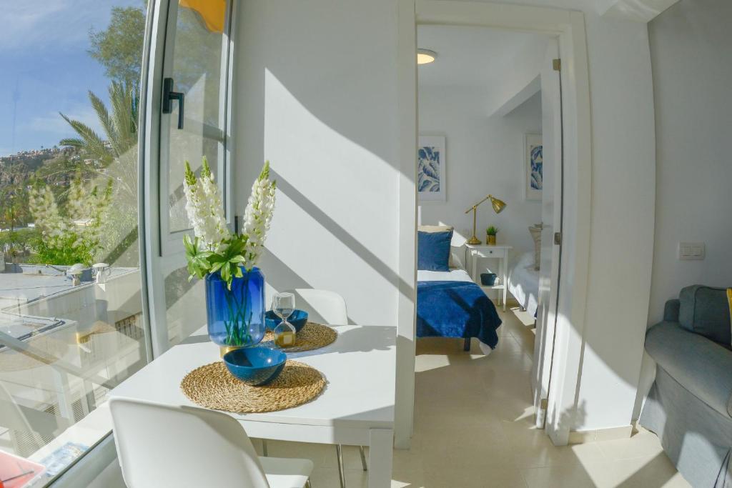 サンアグスティンにあるSunny Sea View Accommodation Gran Canariaのリビングルーム(テーブル、椅子、窓付)