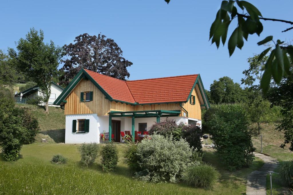 ein Haus mit rotem Dach auf einem Feld in der Unterkunft Kellerstöckl Naturoase Gaas in Eberau