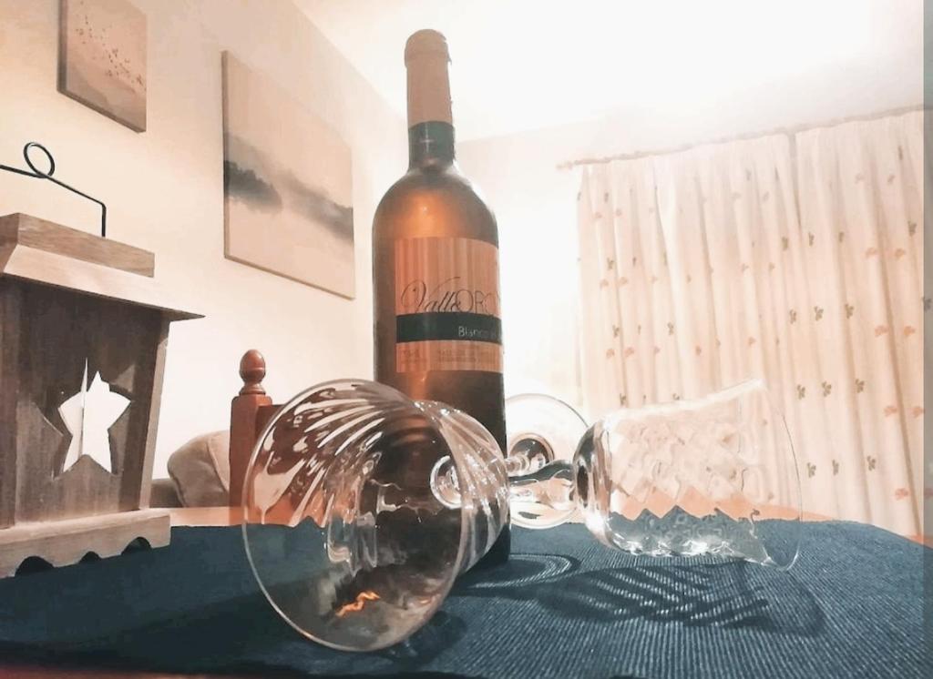 een fles wijn en een glas op een tafel bij Cozy apartment + parking Playa San Juan in Guía de Isora