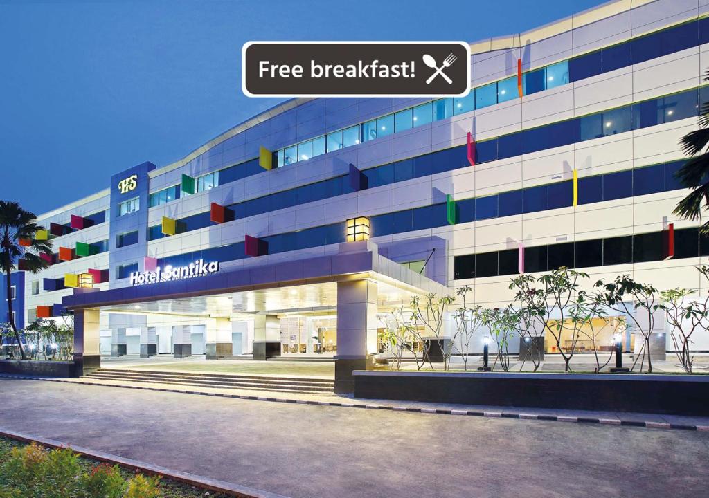 a building with a free breakfast sign in front of it at Hotel Santika Kelapa Gading in Jakarta