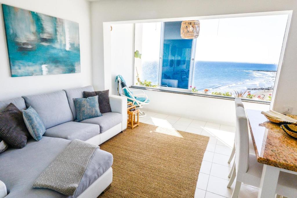a living room with a couch and two windows at Dreamy Sea View Accommodation Gran Canaria in San Agustin