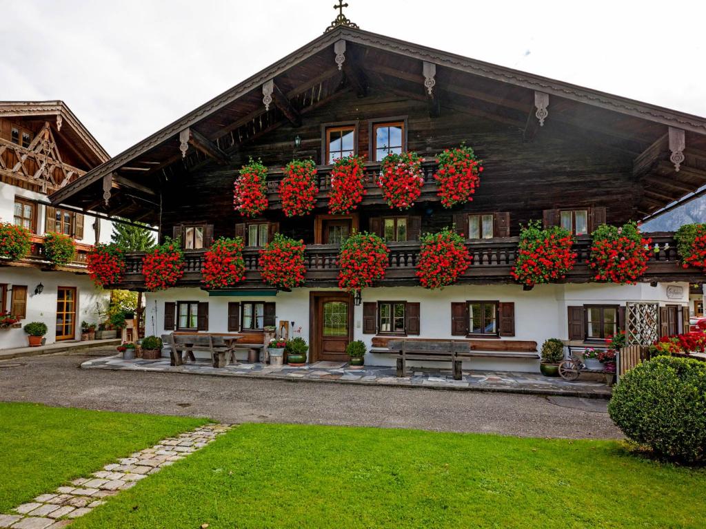 a building with lots of red flowers on it at Großhuberhof in Kiefersfelden