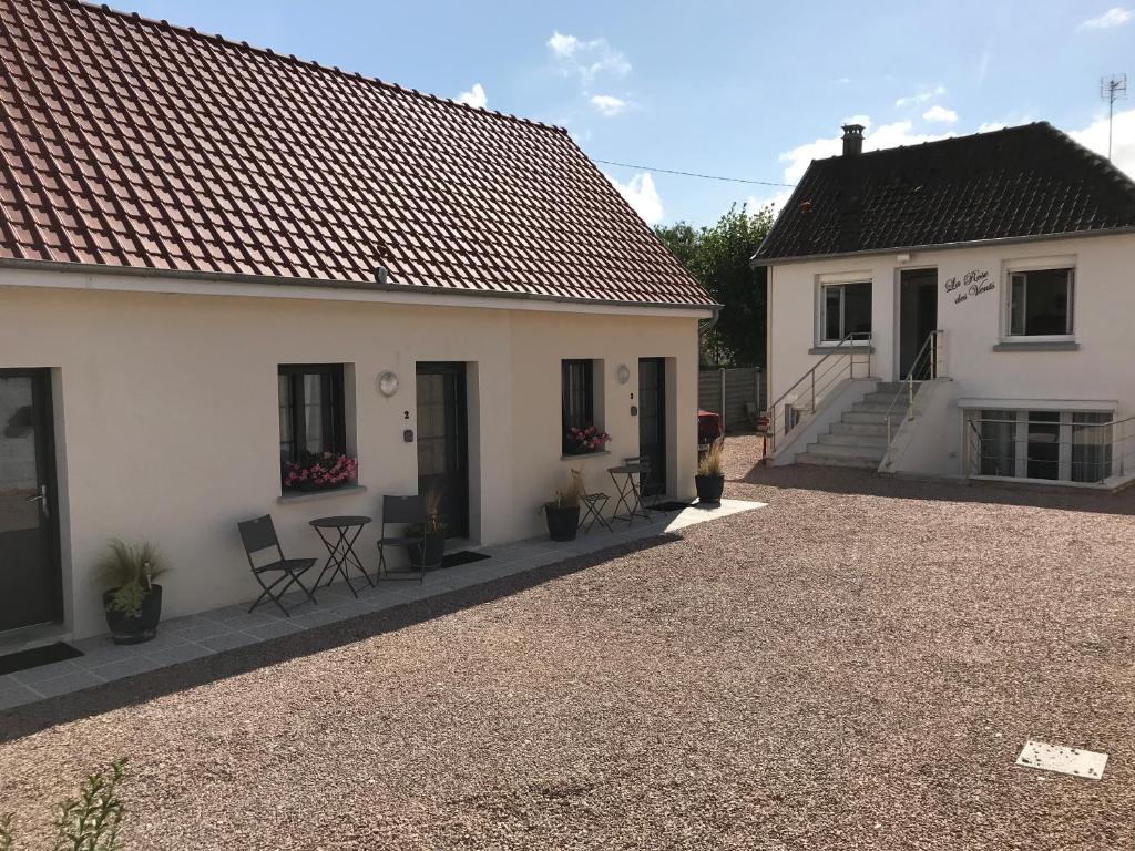 uma casa branca com um alpendre e um pátio em La Rose des Vents em Le Crotoy