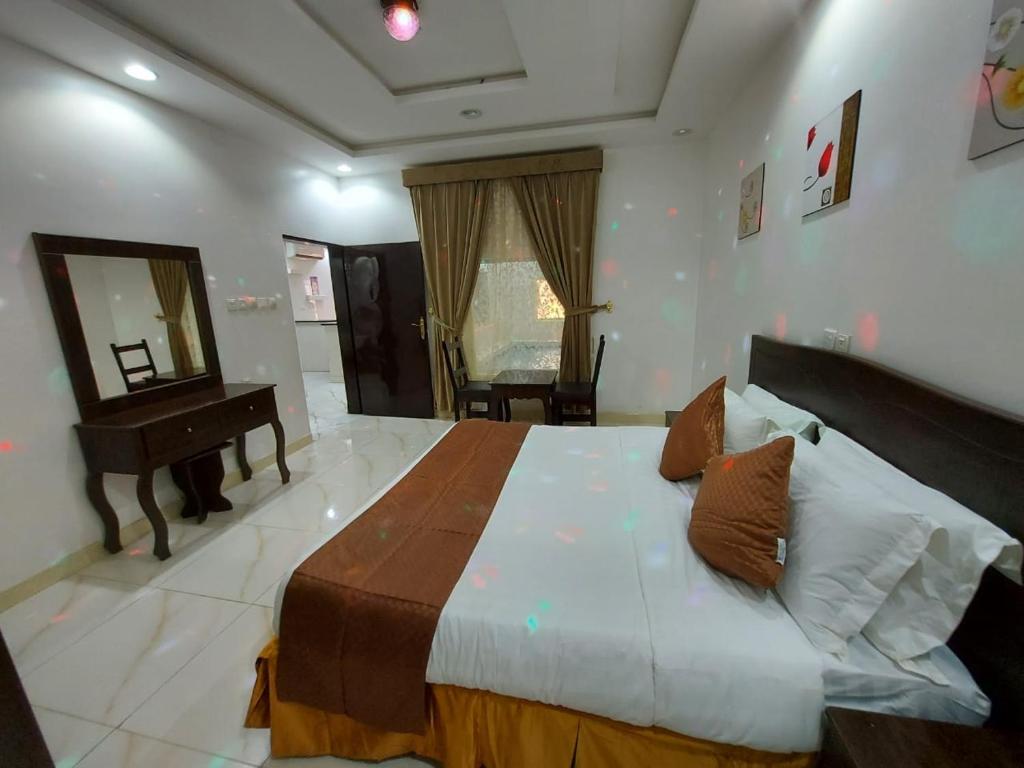 een slaapkamer met een groot bed met een spiegel en een piano bij شاليهات سويت هوم الدرب الكدره in Ad Darb