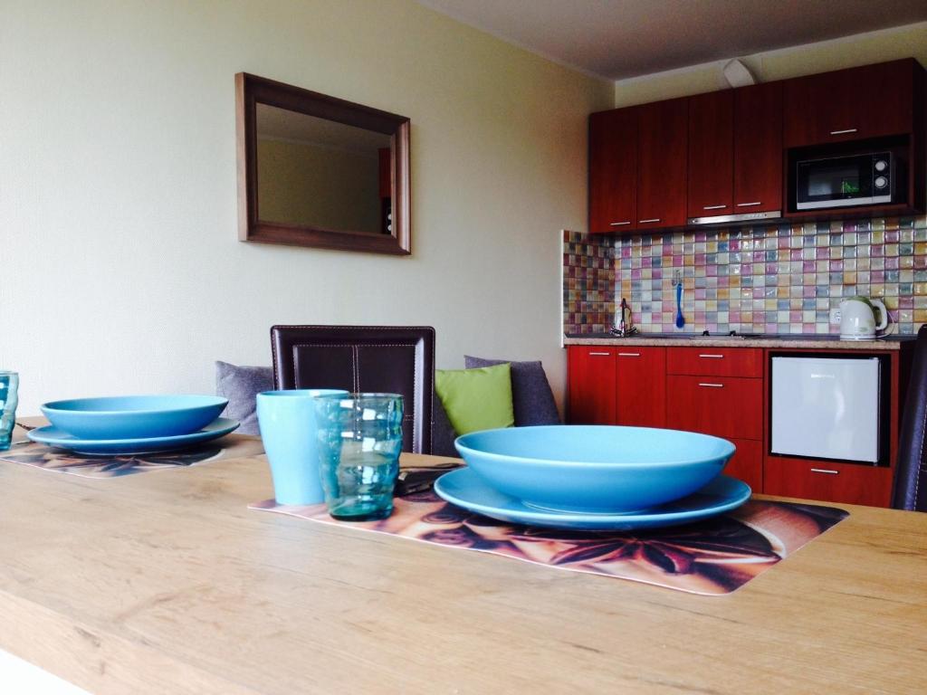 una cocina con 2 cuencos azules sobre una mesa de madera en A Cozy Central Studio, en Druskininkai