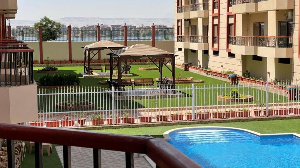 un balcone con vista su un edificio con piscina di Kemet Apartment luxor a Luxor
