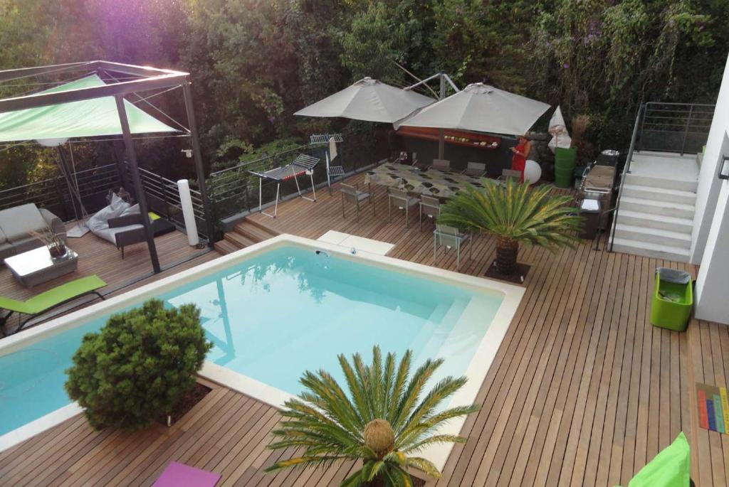 una terraza de madera con vistas a una piscina. en SUPERBE MAISON DE VILLE en Cannes