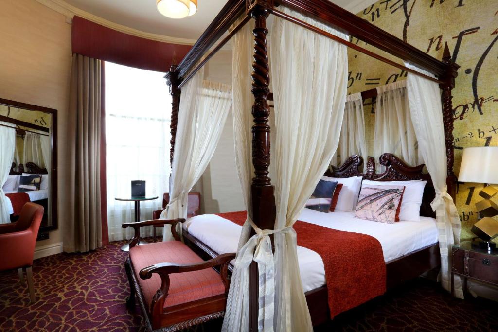 1 dormitorio con cama con dosel y silla en Liverpool Inn Hotel, Sure Hotel Collection by Best Western, en Liverpool