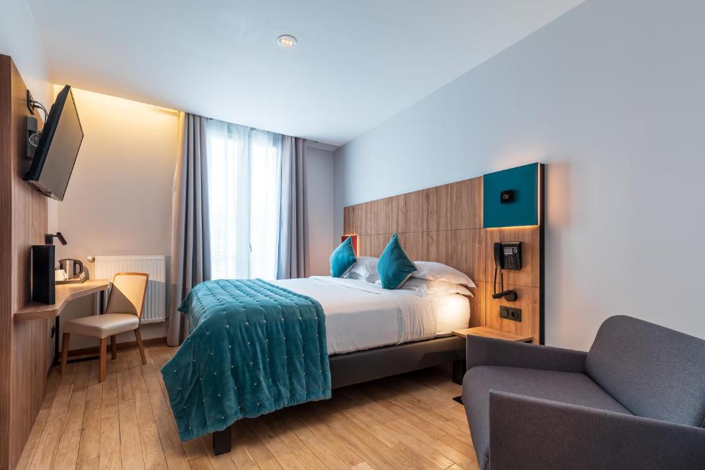 a hotel room with a bed and a chair at Hôtel de Bellevue Paris Gare du Nord in Paris