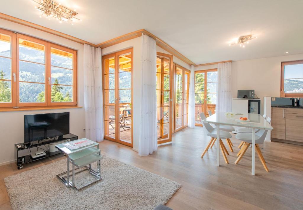 a living room with a table and a dining room at Panoramapark Soleil Chalet A in Wengen