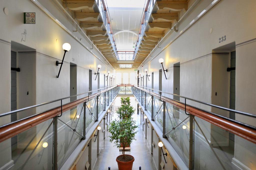 um corredor com dois vasos de plantas num edifício em STF Långholmen Hostel em Estocolmo