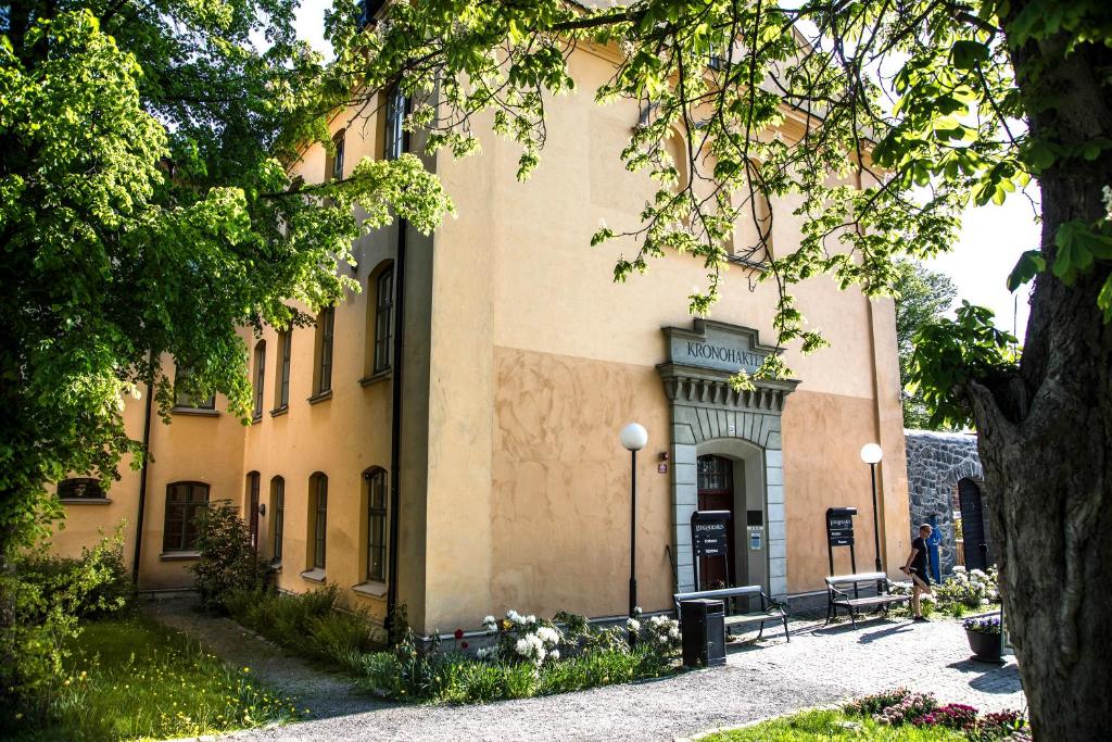 ein Gebäude mit einem Baum davor in der Unterkunft STF Långholmen Hostel in Stockholm