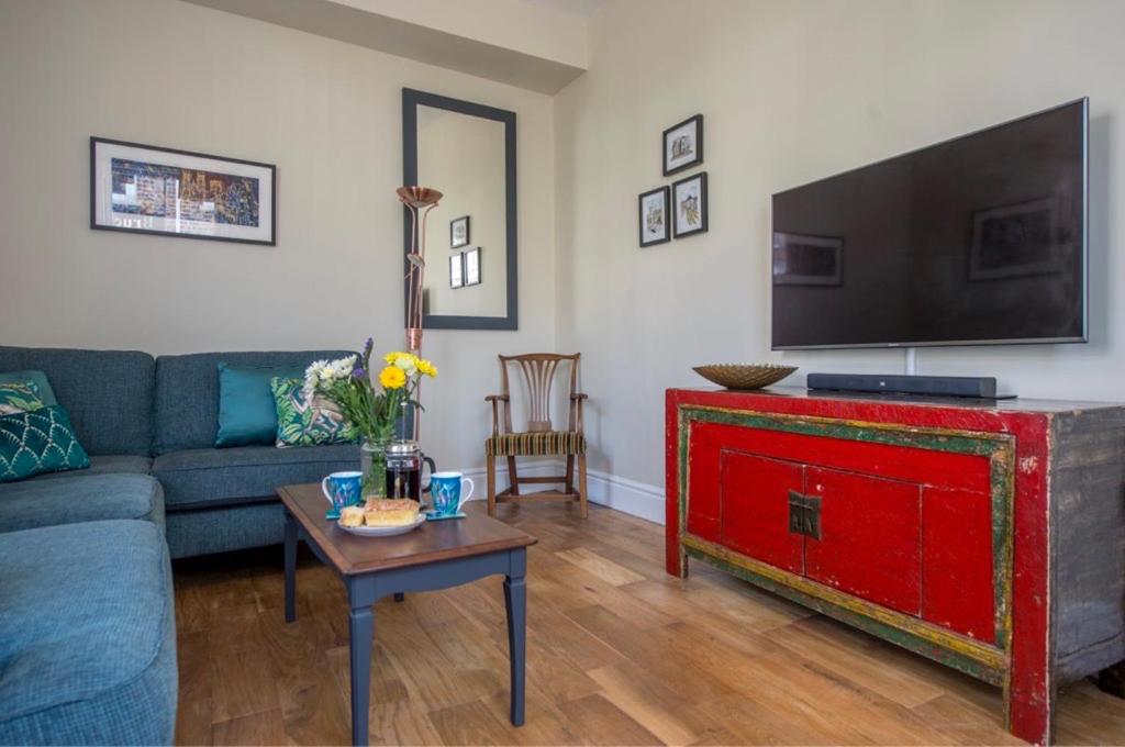 een woonkamer met een bank, een tv en een tafel bij Spencer House in York