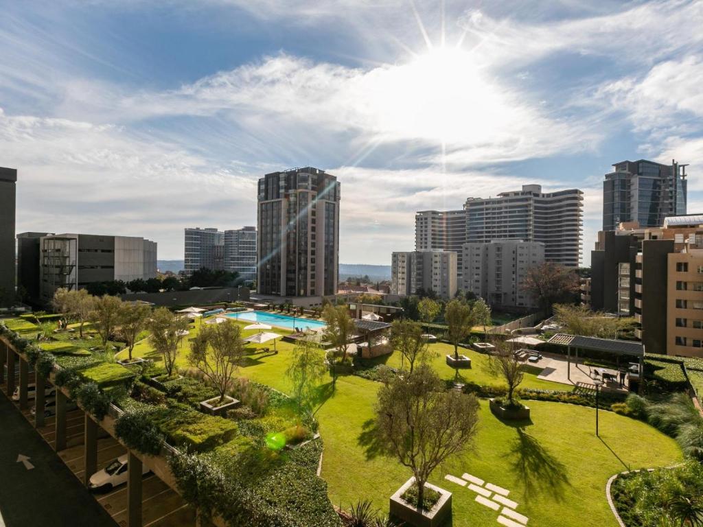 un parque en una ciudad con edificios altos en RAD STAYS - 60 Westpoint 89 Grayston Dr Morningside, en Johannesburgo