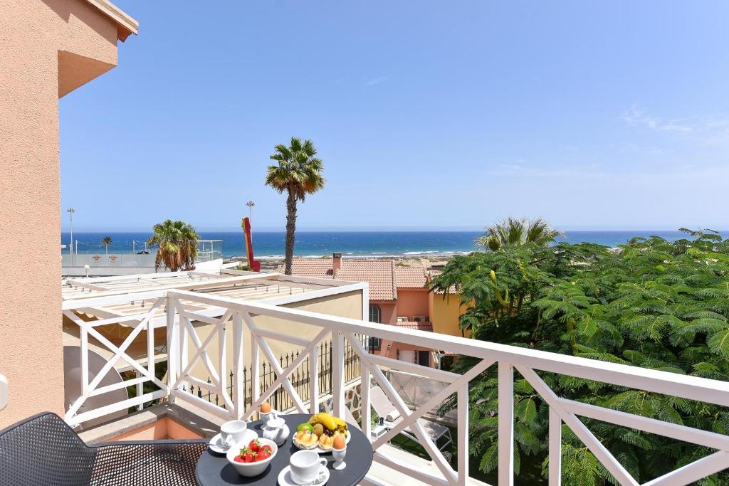 un tavolo con un cesto di frutta su un balcone con vista sulla spiaggia di Chalet Santa Ana 15 by VillaGranCanaria a Playa del Ingles