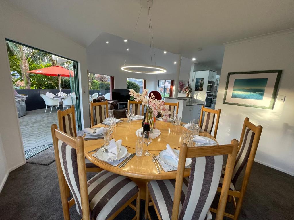 a dining room with a wooden table and chairs at Luxury Home Next to Ocean and Walkway in New Plymouth