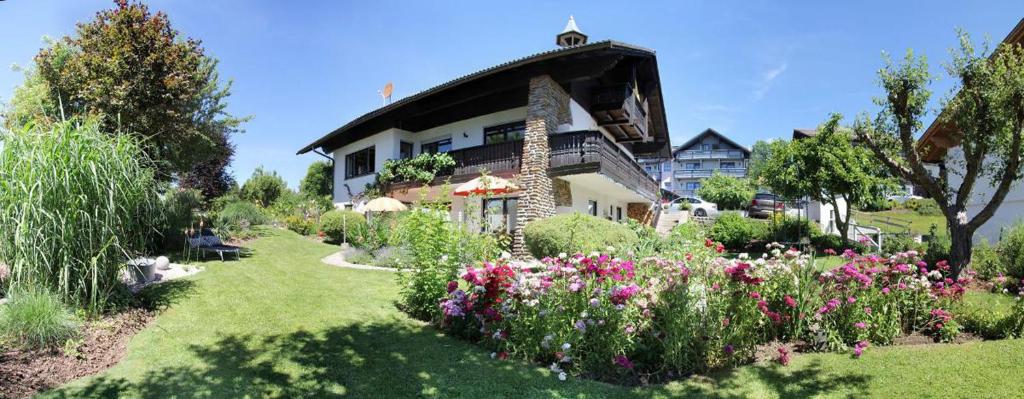 a house with a garden with flowers in the yard at Am Schmuggerbühl in Bodenmais