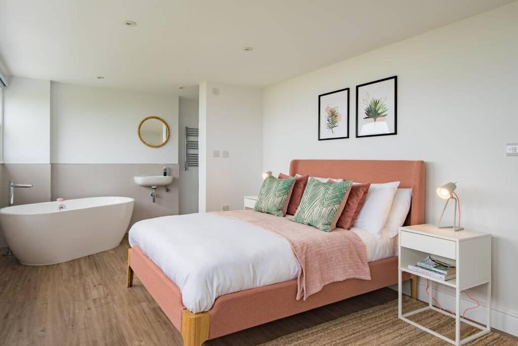 a bedroom with a large bed and a bath tub at The Lookout - Stunning sea view apartment in Deal