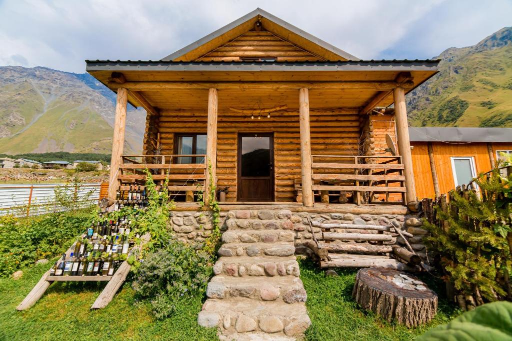 Old Hut في كازباجي: كابينة خشب بها درج يؤدي إلى الباب