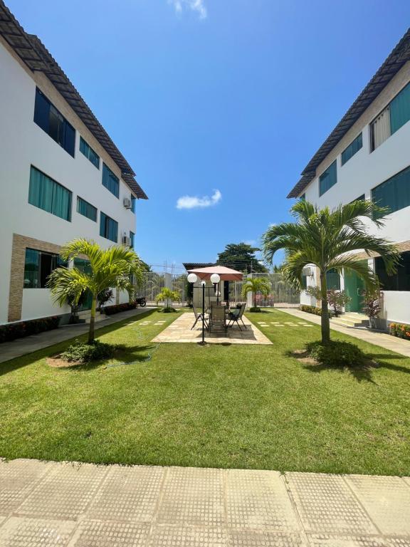 un parque frente a un edificio con palmeras en Flat Residence Maragogi, en Maragogi