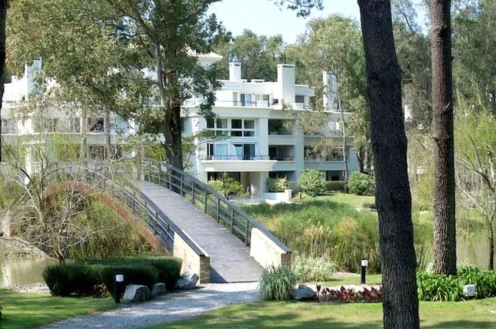 een groot wit gebouw midden in een park bij Green Park Apartamento de 1amb en PB con Jardín in Punta del Este