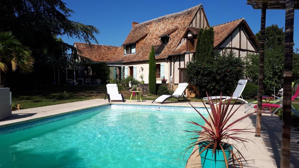 ein Pool vor einem Haus in der Unterkunft En pleine campagne, proche du Mans - chambre d'hôtes in Fillé
