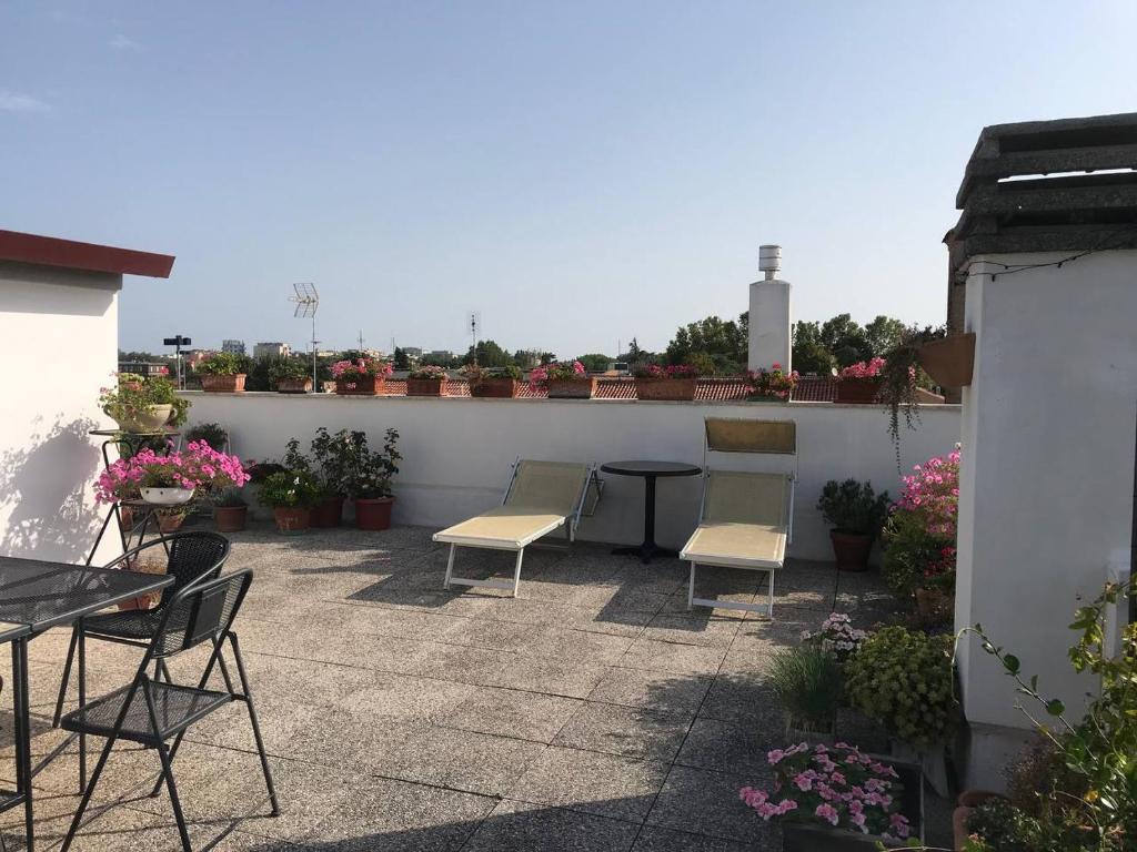 eine Terrasse mit Stühlen, einem Tisch und Blumen in der Unterkunft B&B RoofTop51 in Rimini