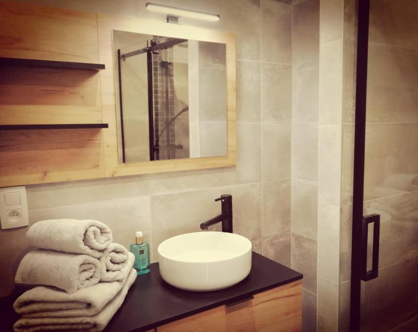ein Badezimmer mit einem Waschbecken und Handtüchern auf der Theke in der Unterkunft L'Essentiel à Francorchamps in Francorchamps