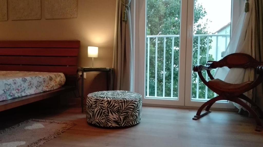 a bedroom with a bed and a chair next to a window at CASA MONTEFINESE in Casamassima