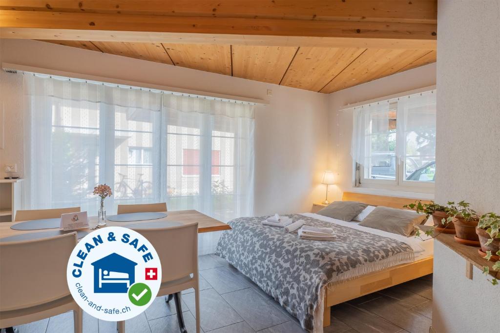 1 dormitorio con 1 cama, escritorio y ventanas en Efeu en Interlaken