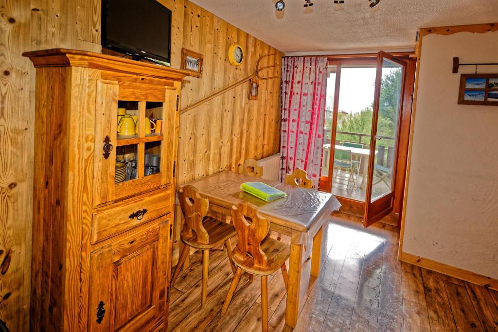 ein Esszimmer mit einem Tisch und einem TV in der Unterkunft le burel la triade 4 personnes in Lanslevillard