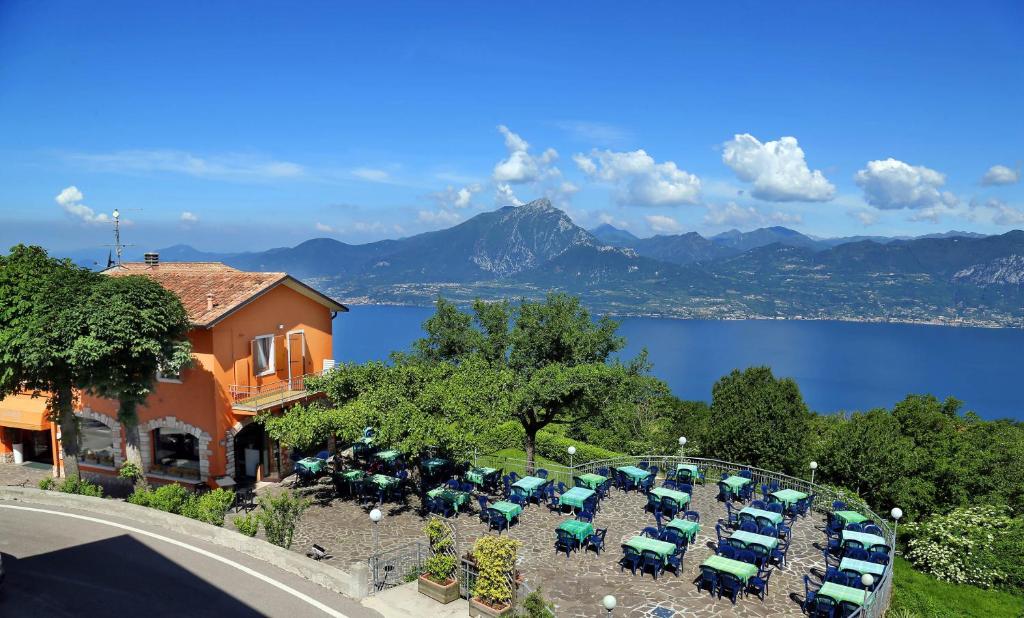 un grupo de coches estacionados al lado de un edificio con un lago en Hotel Giardinetto, en San Zeno di Montagna