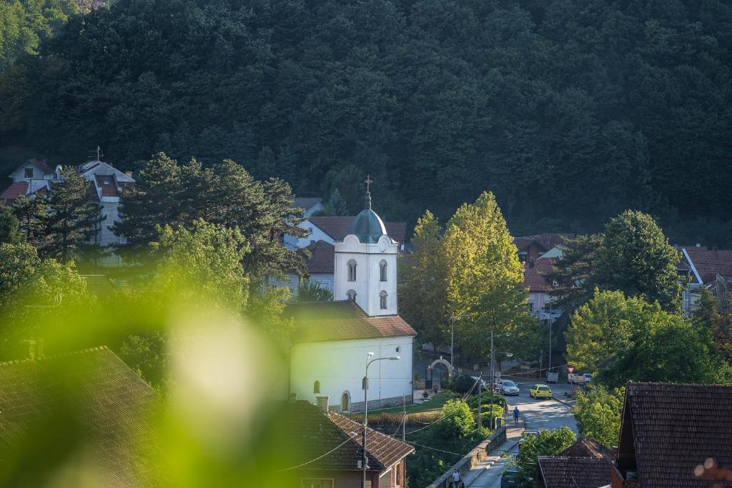 a small white church with a steeple in a town at Apartments Vidik in Ivanjica