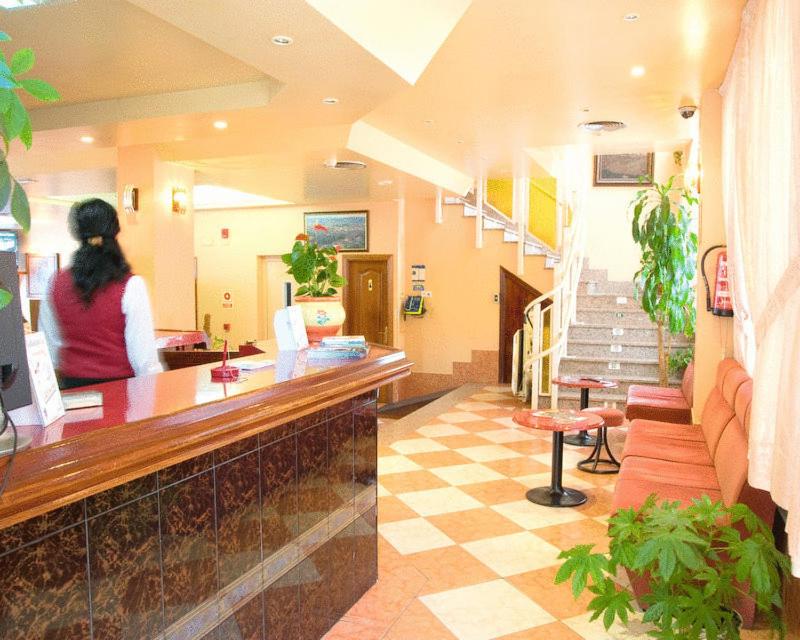 a woman is sitting at a counter in a hospital at Hotel Can-Vic in Guadalajara