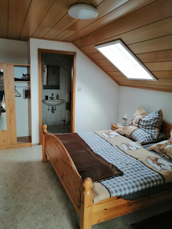 Schlafzimmer mit einem großen Holzbett und einem Dachfenster in der Unterkunft Familie Barth in Kleinmürbisch
