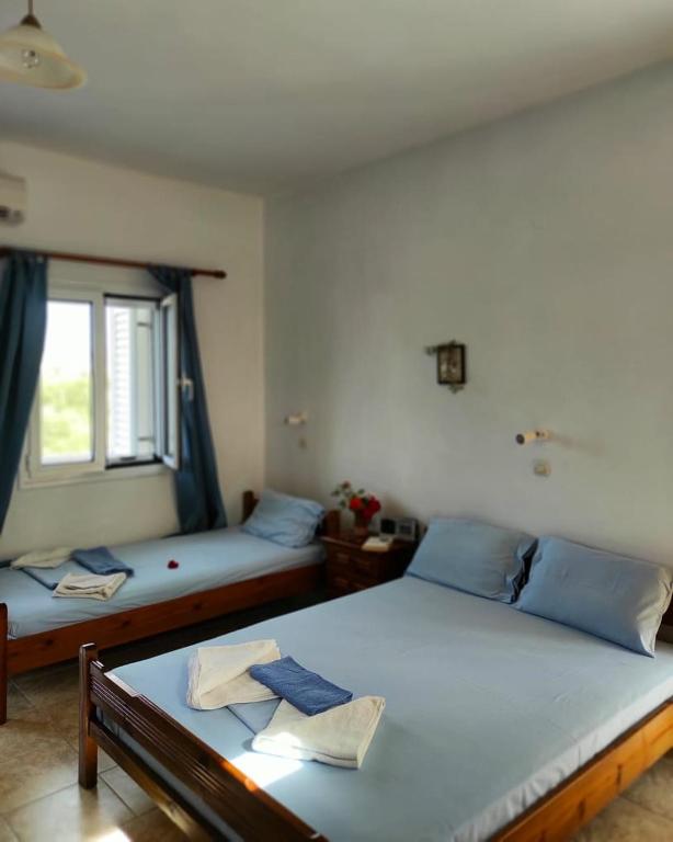 a bedroom with two beds and a window at studios.maria.anna in Kamilari