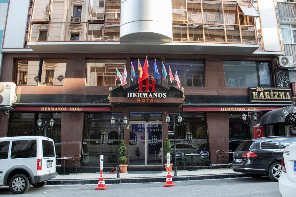 a building with a sign for a restaurant with flags on it at Hermanos Hotel in Istanbul