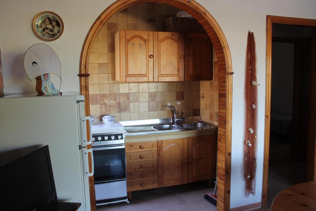 a kitchen with a stove and a sink and a refrigerator at Ville Alba & Azzurra in Polignano a Mare