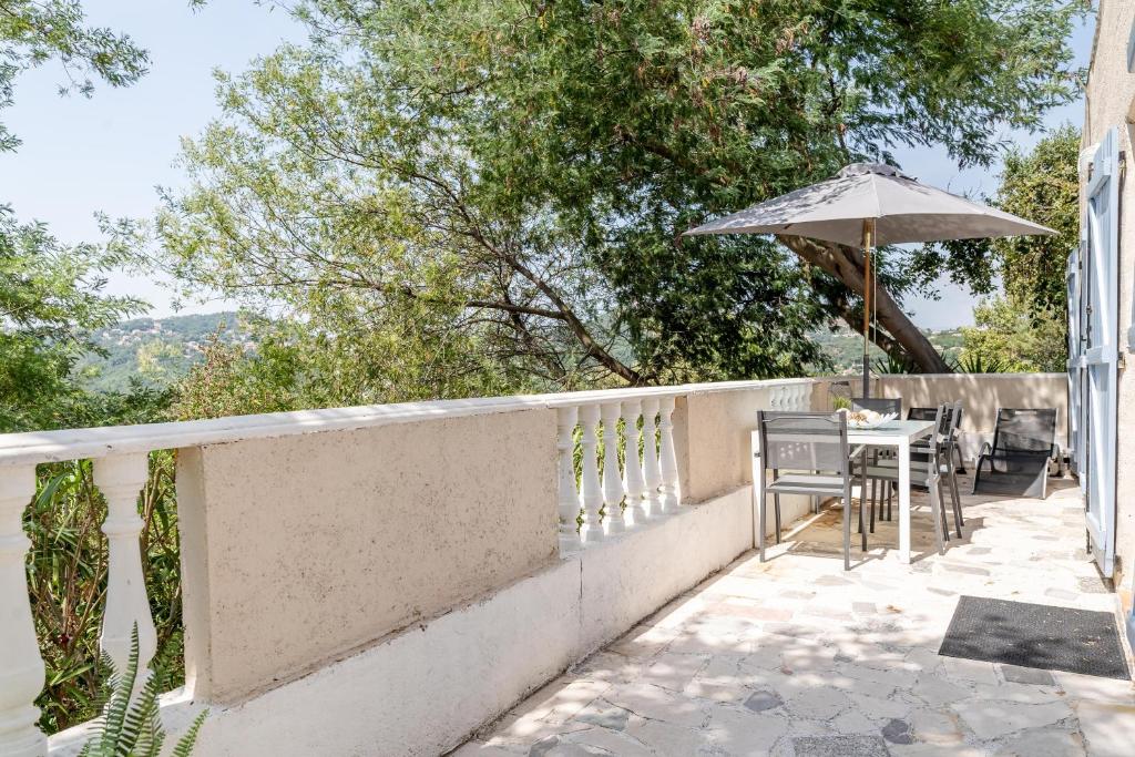 un balcon avec une table et un parasol dans l'établissement Le Petit Thao, à Fréjus