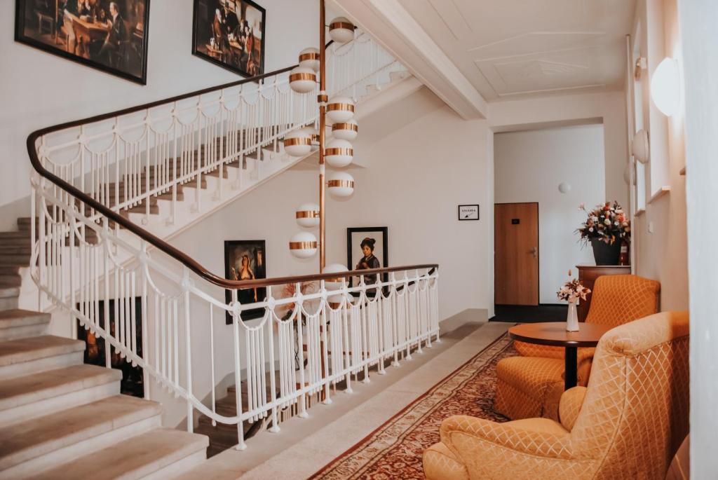 - un escalier dans un salon avec deux chaises et une table dans l'établissement B&B Hotel Praha, à Nový Jičín