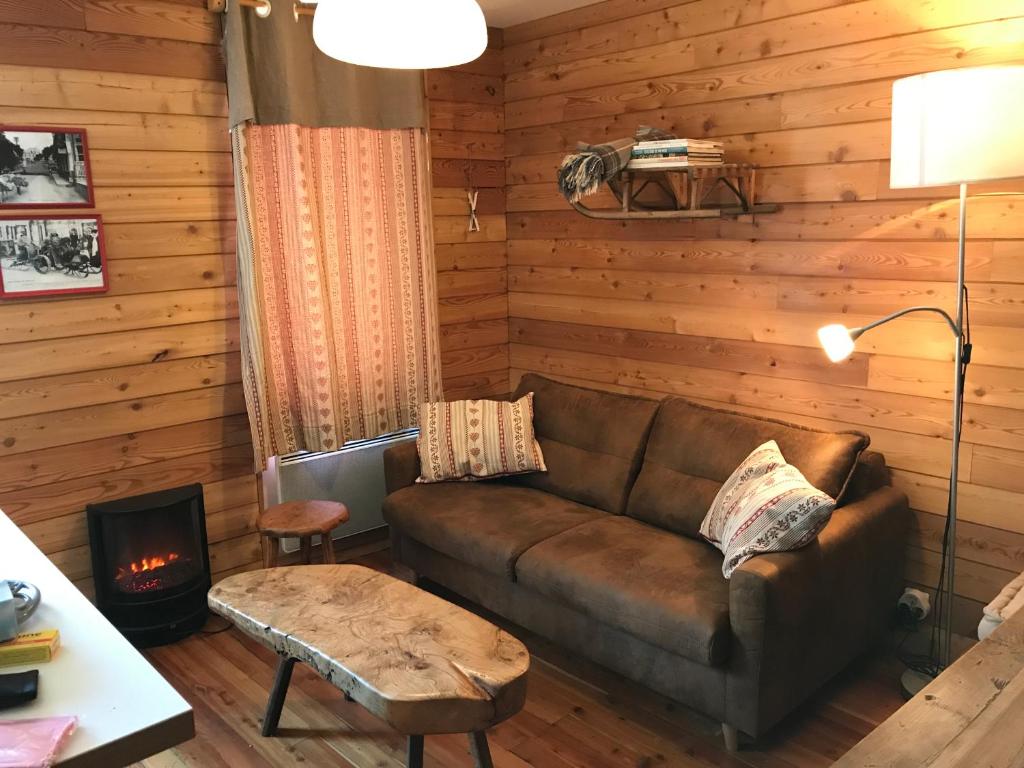 a living room with a couch and a fireplace at appartement style chalet centre Barcelonnette in Barcelonnette