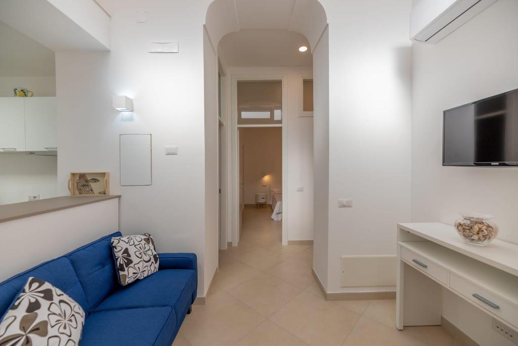 a living room with a blue couch and a tv at Marina Grande Holiday Apartment in Capri in Capri