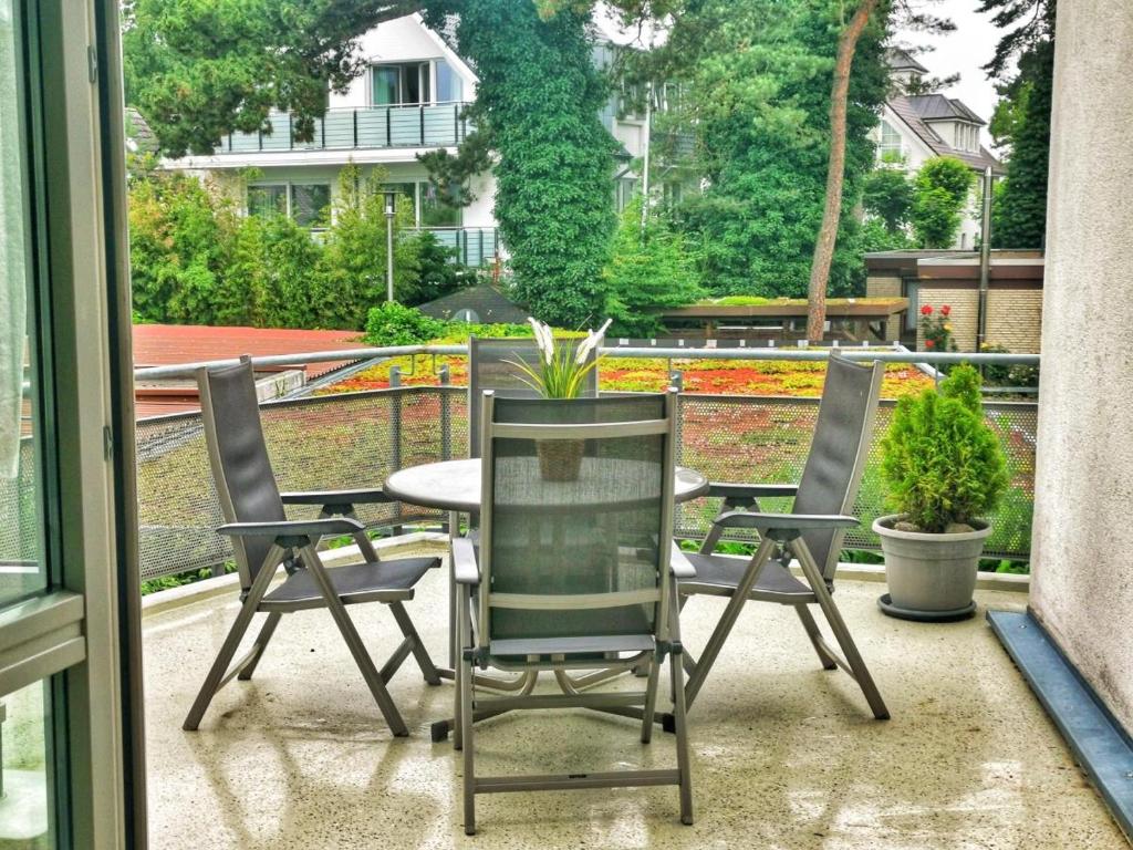 eine Terrasse mit 3 Stühlen und einem Tisch auf dem Balkon in der Unterkunft Apartmentvermittlung Mehr als Meer - Objekt 23 in Niendorf