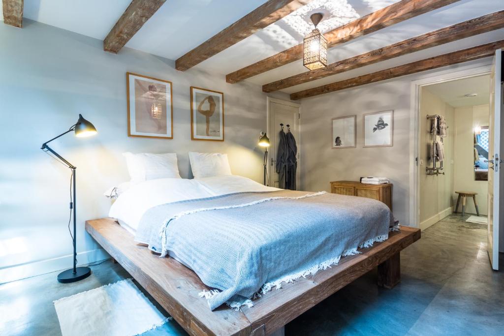 a bedroom with a large bed with a wooden frame at B&B Amsterdam Amstel Apartment in Amsterdam
