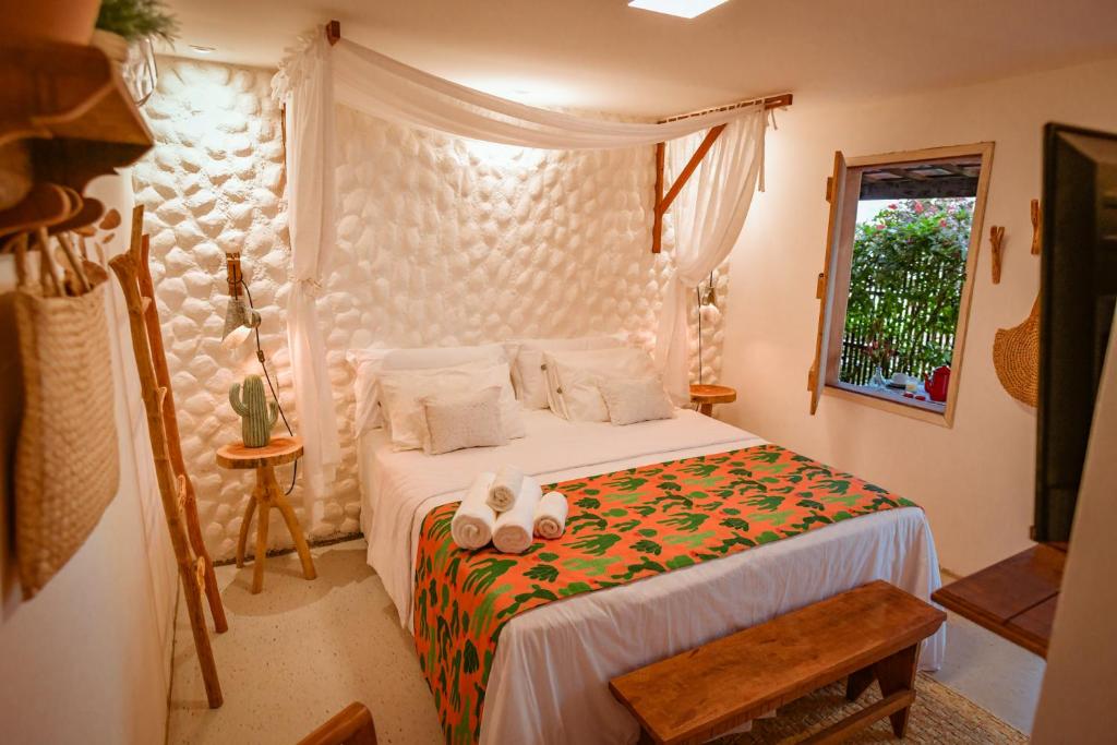 um quarto com uma cama com dois bichos de peluche em EcoCharme Pousada Netuno em Fernando de Noronha