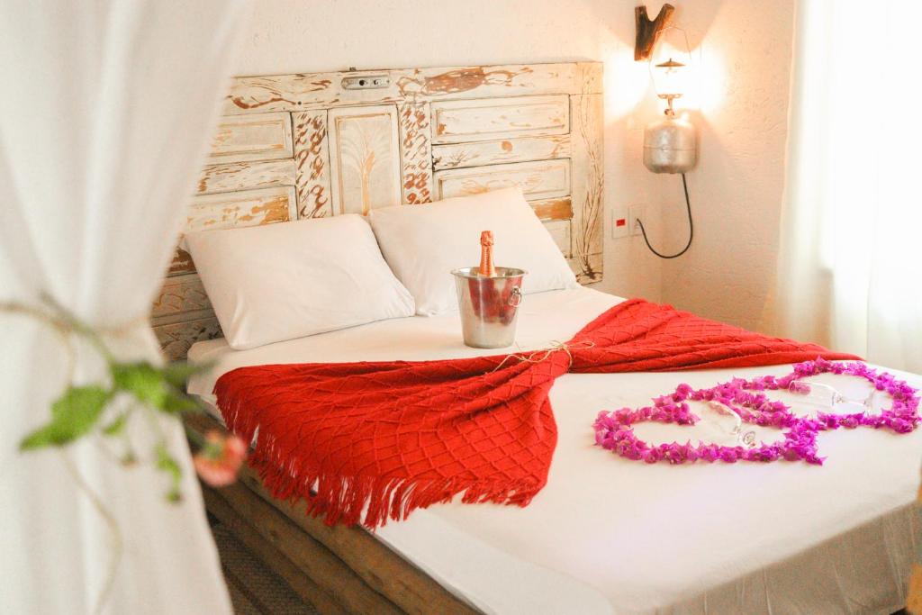 卡羅來納州的住宿－Rancho das Estrelas，一张带红色毯子和项链的床