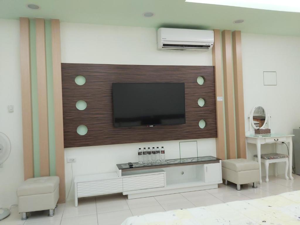 a living room with a flat screen tv on a wall at Happy Heart B&amp;B in Taitung City