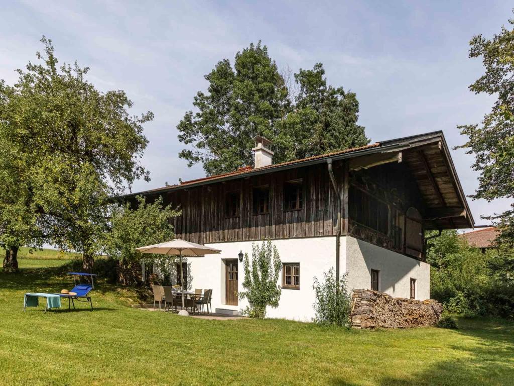 a small white house with a wooden roof at Ferienhaus Nöstlbach in Pittenhart