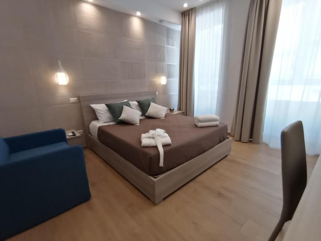 een slaapkamer met een bed en een blauwe stoel bij B&B LE MUSE in Barletta