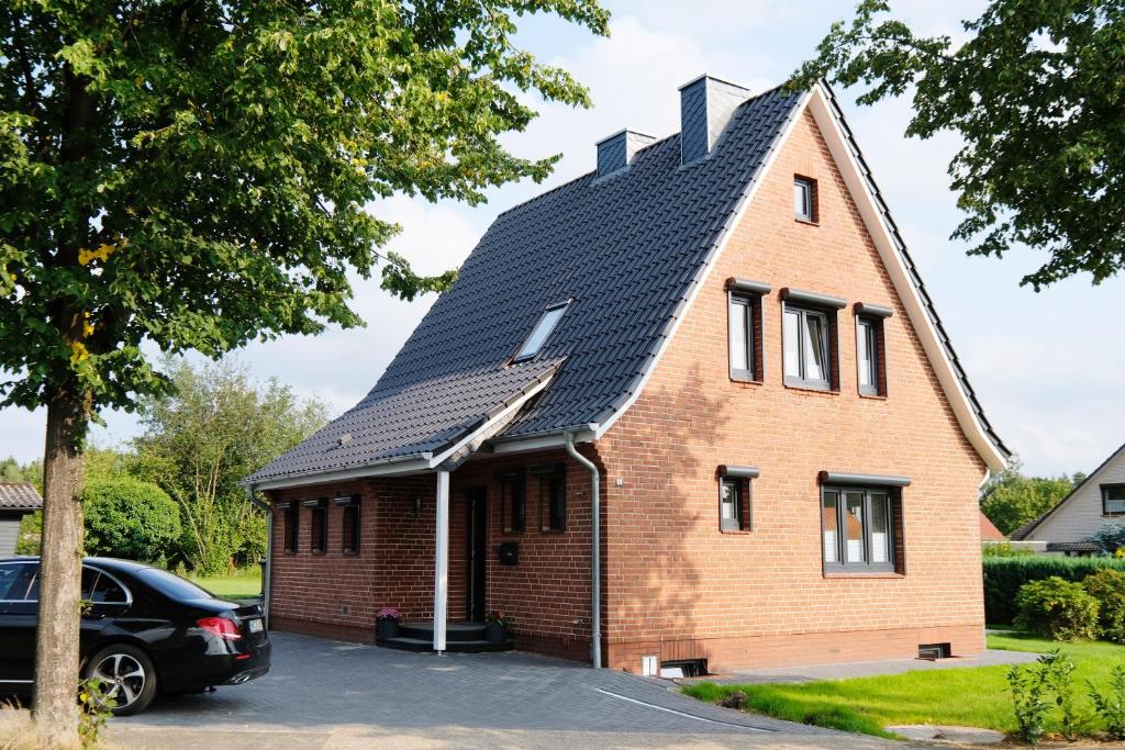una casa con techo de gambrel en lütte Heidepension en Schneverdingen